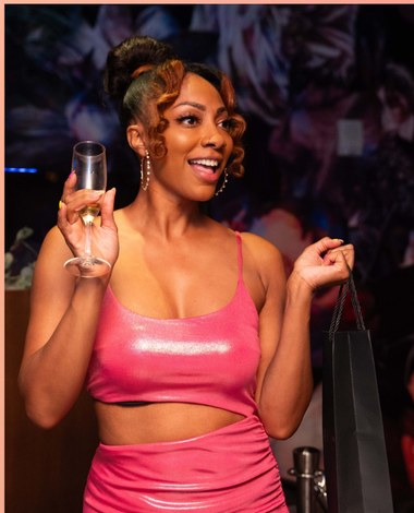 Guest in pink raising a glass of sparkling wine